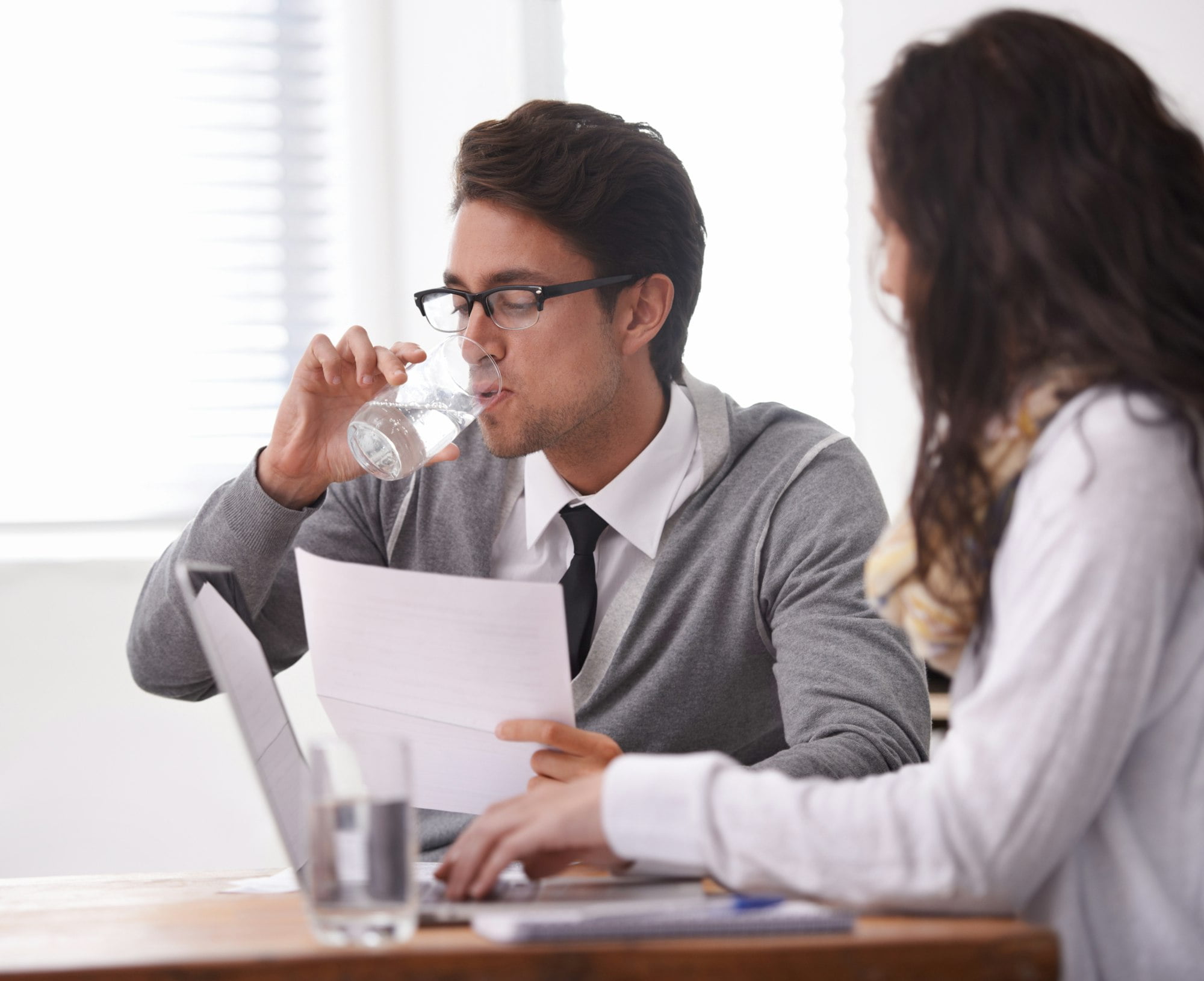 This interview is giving me a dry mouth. A young man drinking water during an interview.